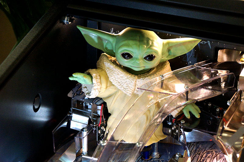 3D-printed model of a character resembling Baby Yoda in a clear plastic display case.