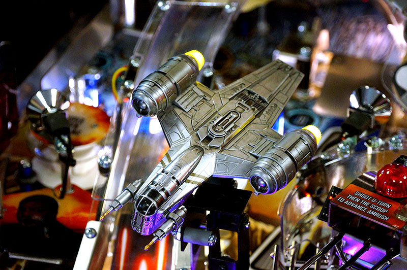Toy spaceship on a pinball machine with colorful lights and details