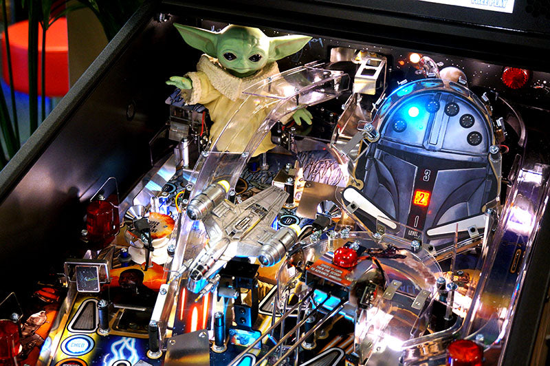 Pinball machine with Star Wars-themed figures including a green character and R2-D2.