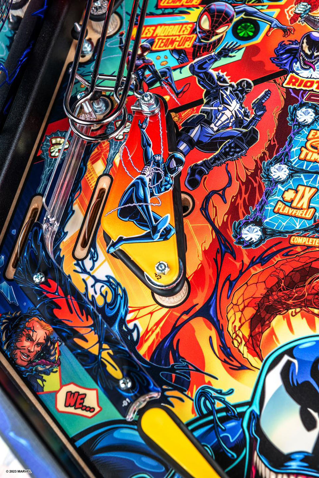Close-up of a colorful pinball machine with superhero graphics