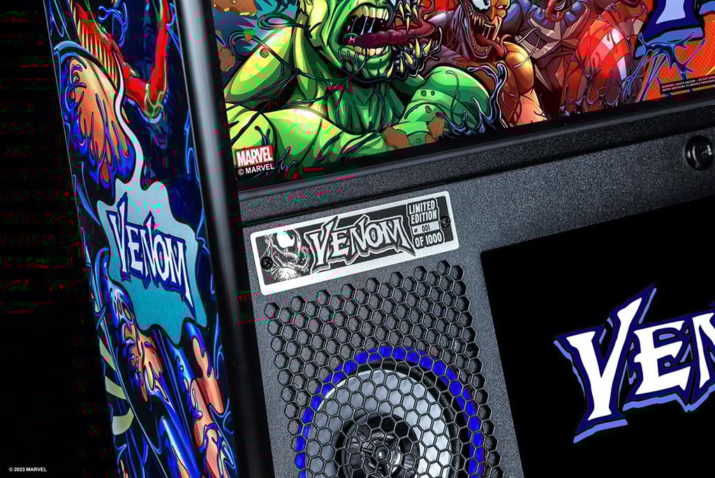 Close-up of a Marvel Venom pinball machine with colorful artwork and 'Venom' branding.