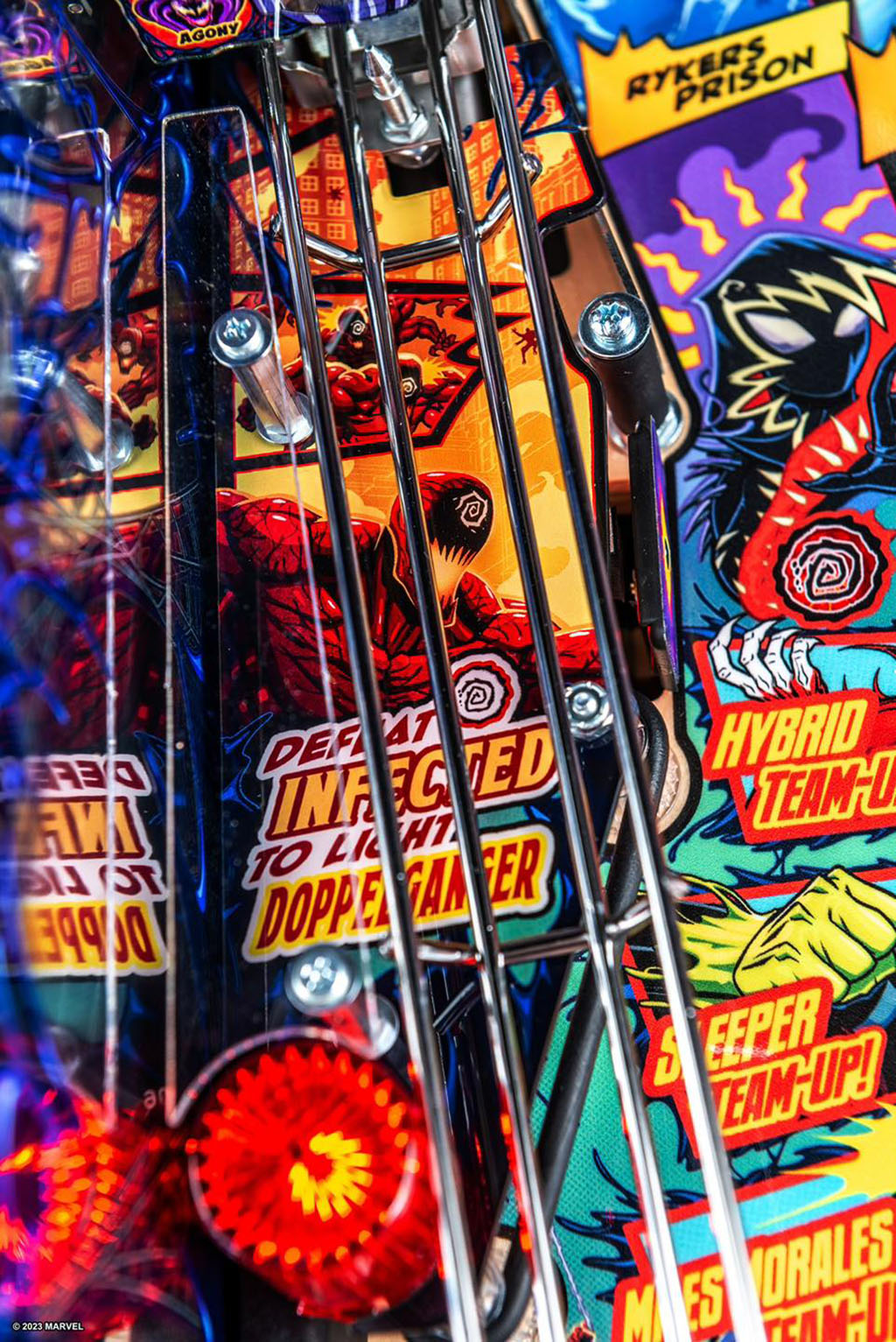 Close-up of a colourful pinball machine with various marvel themed graphics and text. 