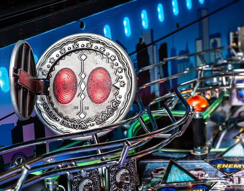 Close-up of a coin with red centers on a pinball machine, with colorful lights in the background.