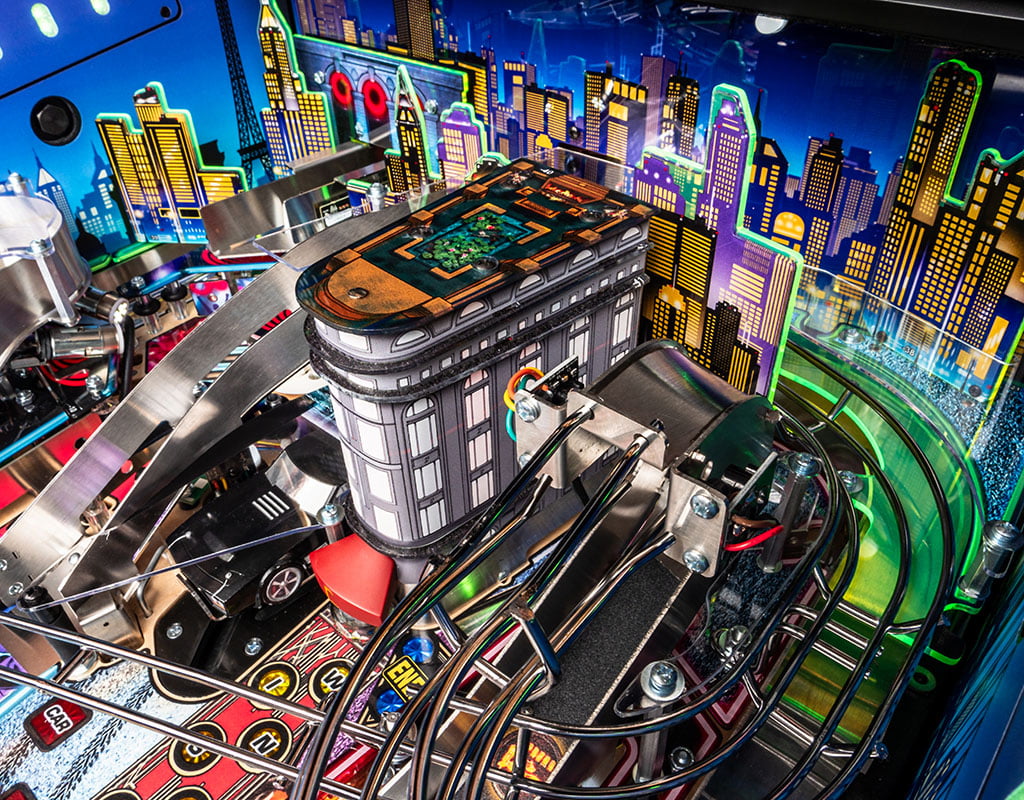 Close-up of a pinball machine with a cityscape background