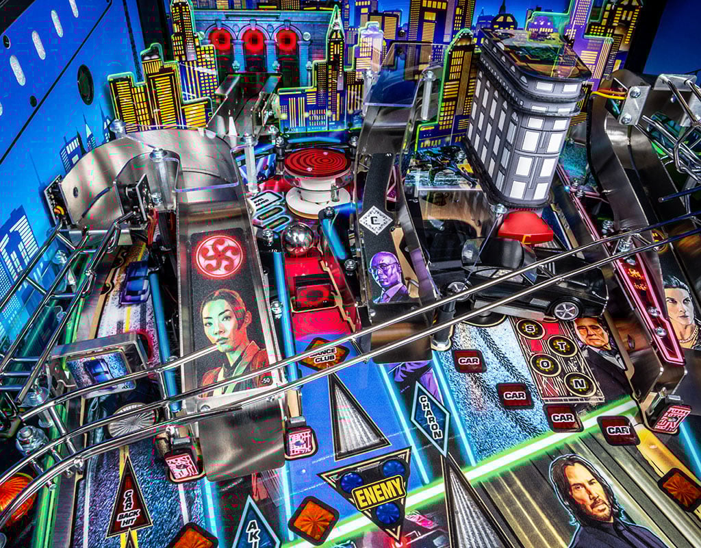 Close-up of a colourful pinball machine with various symbols and figures.