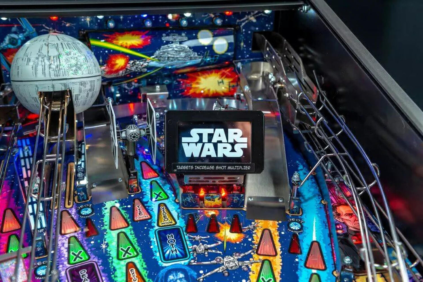 Close-up of a Star Wars pinball machine with colourful lights and game elements.