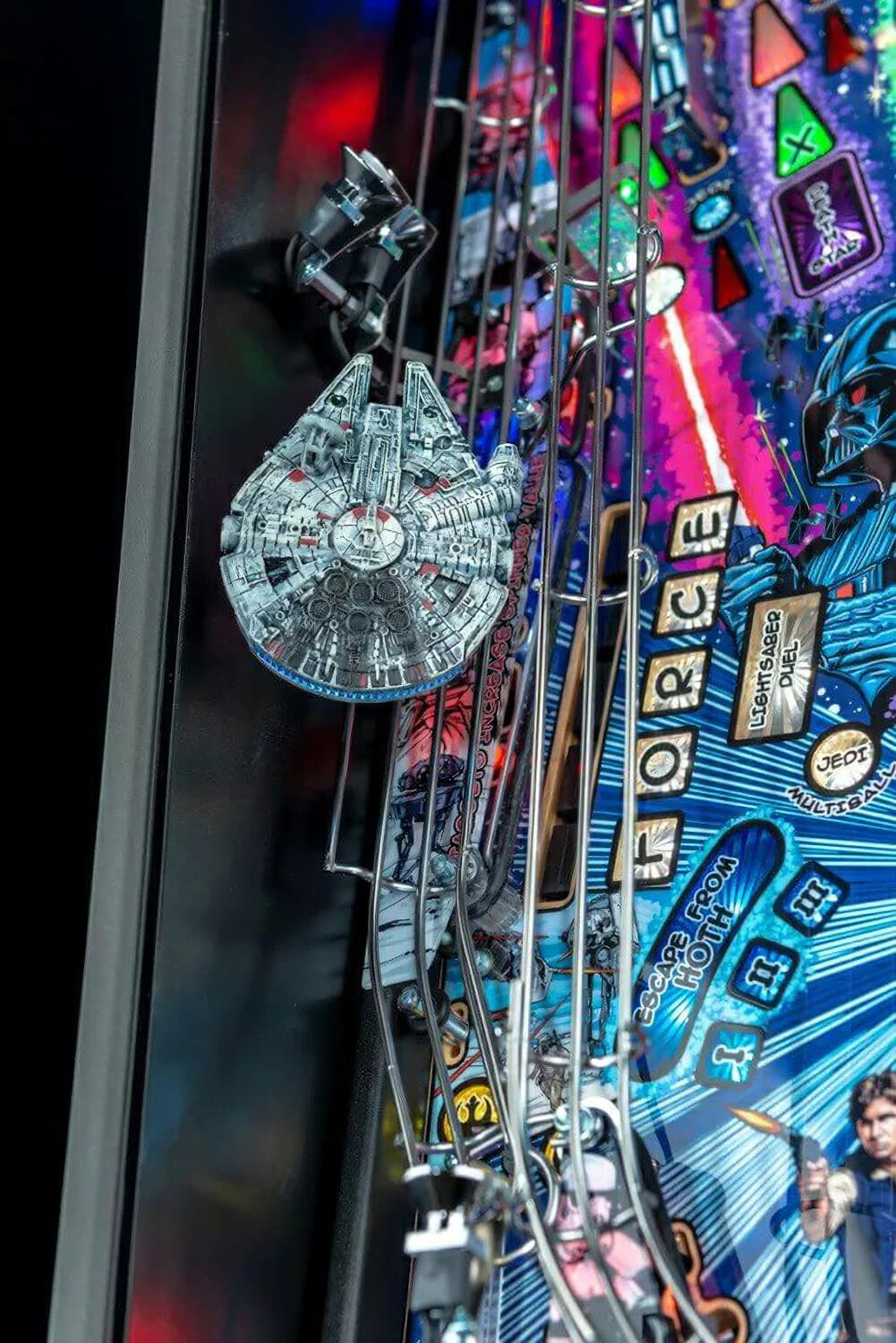 Close-up of a Star Wars-themed pinball machine with various pins and characters.
