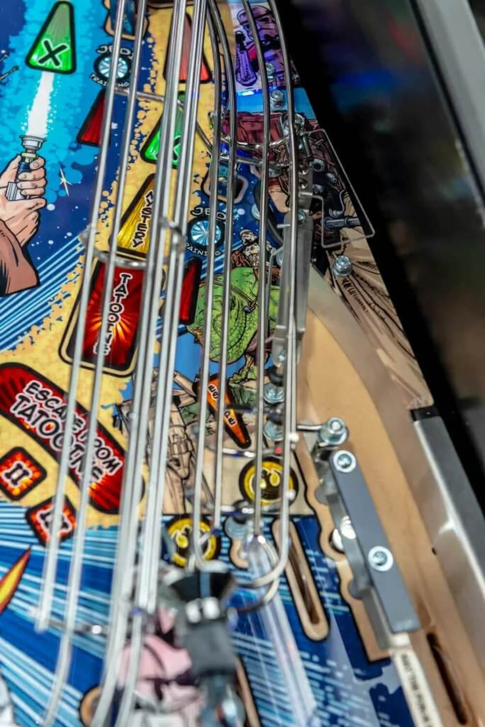 Close-up of a pinball machine with colourful Star Wars artwork and mechanical components.