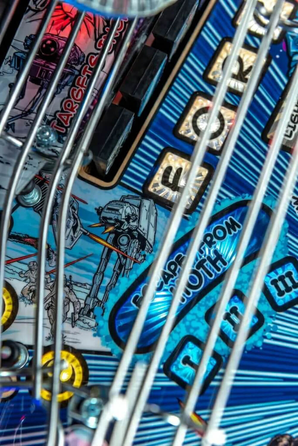 Close-up of a pinball machine with visible branding and artwork.