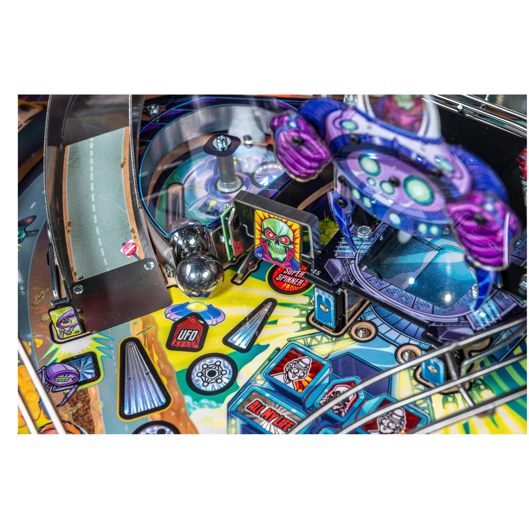 Close-up of a colorful pinball machine with various components and artwork.